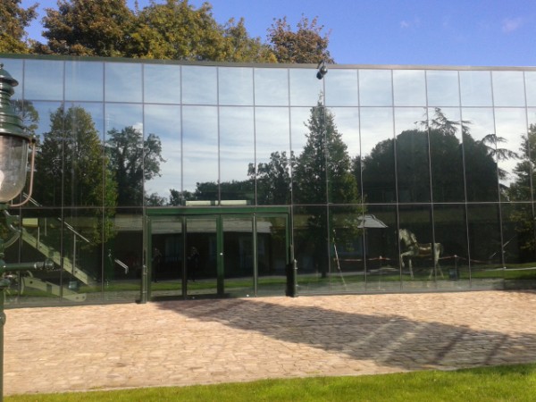 Fully glazed building reflecting surrounding trees at Flint Mill, Wetherby