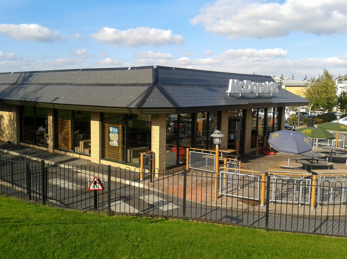 McDonald's restaurant with a glazed single-storey extension and outdoor seating