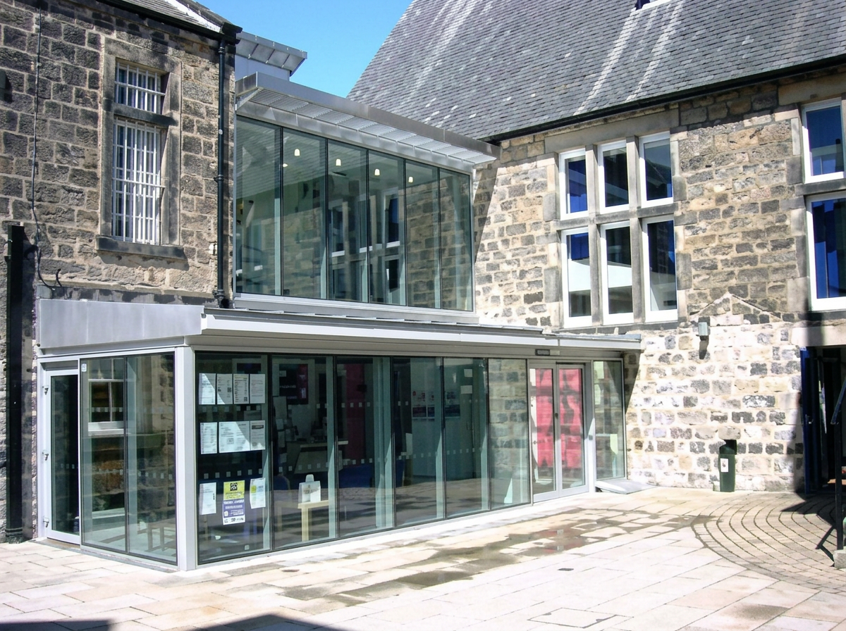 Stone building with a glazed aluminium extension, recorded as Otley Court Houses